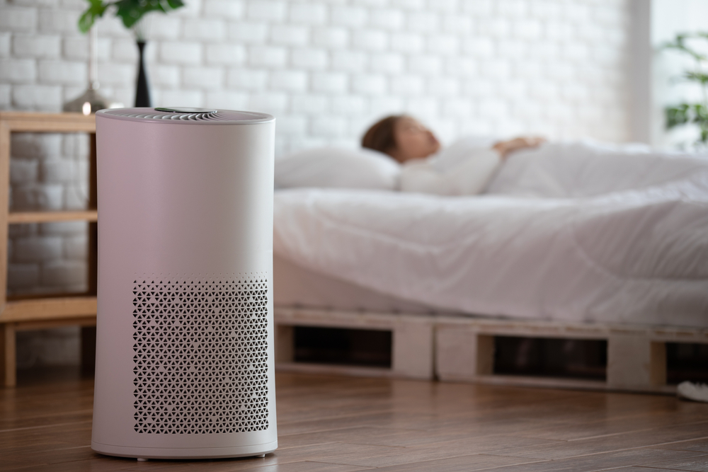 Woman Sleeping With An Air Purifier In Cozy White Bedroom