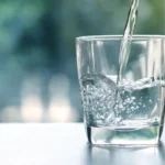 a glass of water being poured into a glass / Top Benefits of Using a Water Purifier - Why Clean Water Matters - Benefits of Using a Water Purifier - Types of Water Purifiers and Their Features - ETA Mold Inpection in Florida