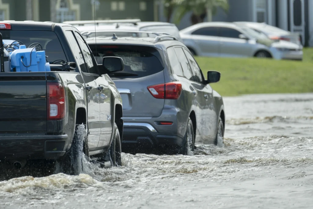 Flooded street with vehicle navigating water. - Flood Damaged Car Problems: A Complete Informative Guide - ETA Mold Florida