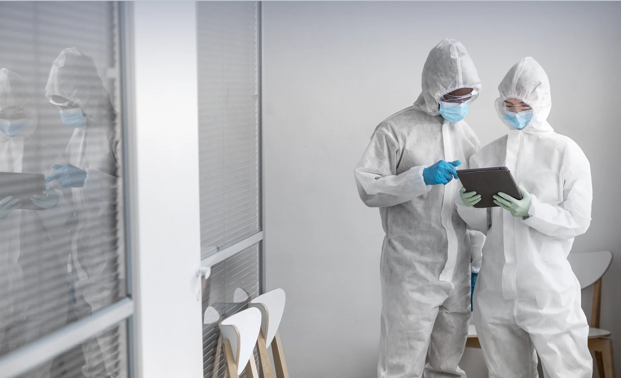 Certified Environmental Testing Agency technicians checking diagnostics and lab metrics on a digital tablet device