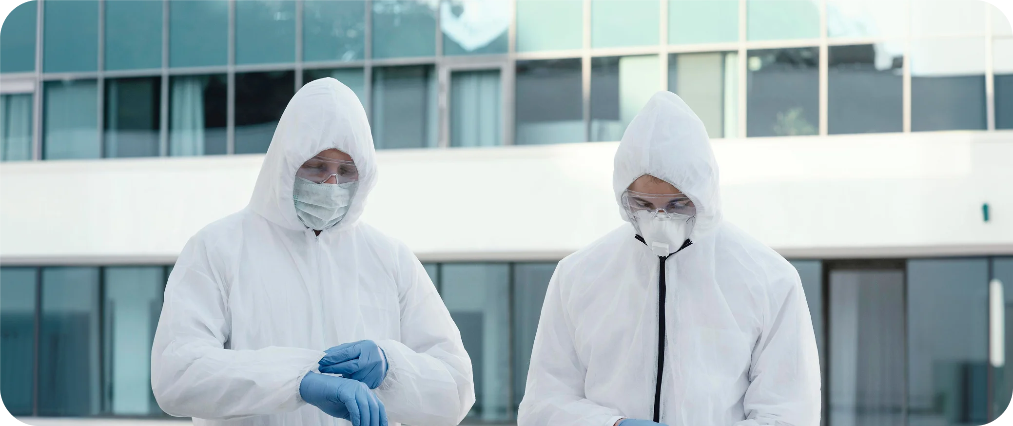 Certified environmental inspectors in hazmat suits assessing a commercial building facility