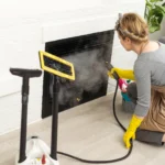 woman cleaning fireplace with steam cleaner - Does Steam Kill Mold? A Complete Guide