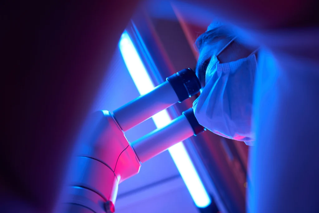 person with microscope conductiong research in labo - Does UV light kill mold?