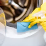 cleaning washing machine with yellow gloves - How to Clean Mold From a Washing Machine
